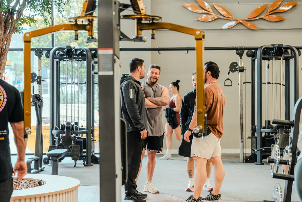 Pessoas conversando entre os aparelhos da Templo Fitness.