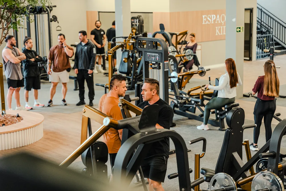 Pessoas conversando e usando aparelhos no salão da Templo Fitness.